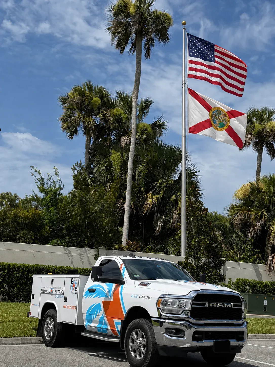 Ellowitz Electric South service truck parked under the American and Florida flags and palm trees