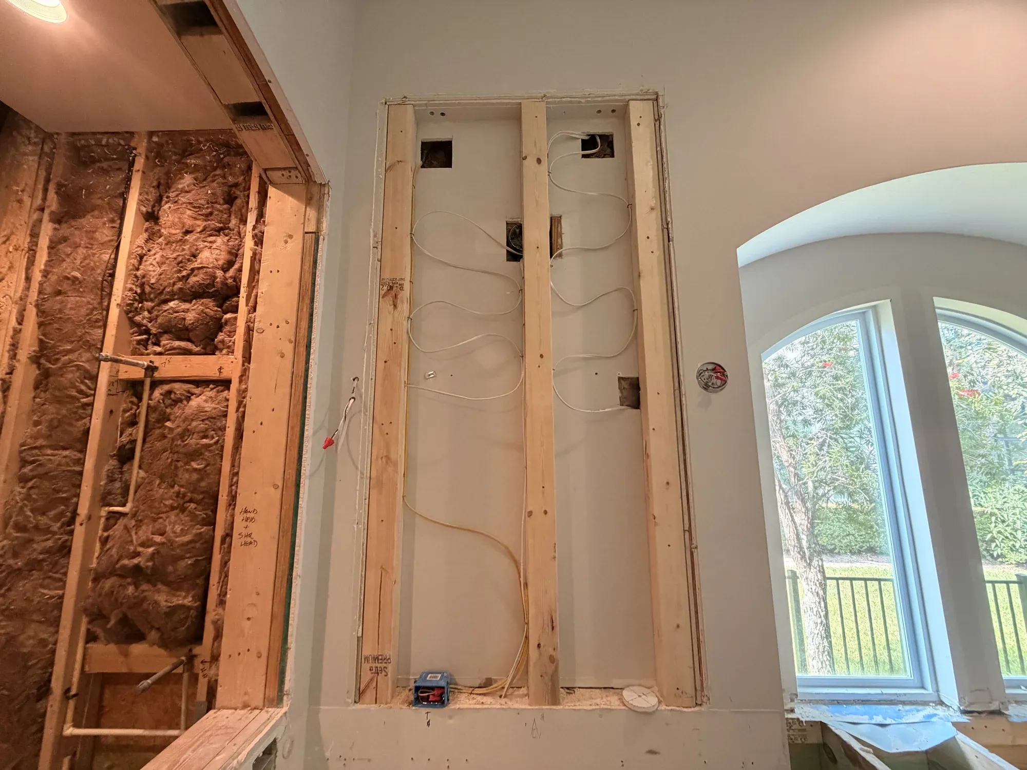 Open wall framing with new outlet and switch boxes wired during a Florida home renovation